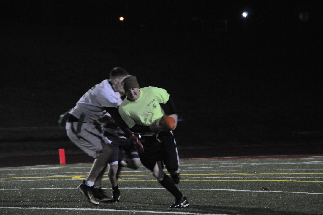 A player for Weapons Training Battalion’s flag football team rushes past a defender trying to get to the end zone during the final game of the season Marine Corps Intelligence Activity at Butler Stadium on Nov. 27. The final score of the game was WTBN 26, MCIA 7.