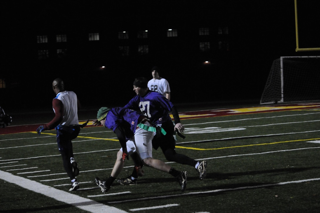 A player for Marine Corps Systems Command’s flag football team evades two opposing players grasps during an American League game at Butler Stadium on Nov. 19. The teams who compete in the league consist of Marines as well as civilians.