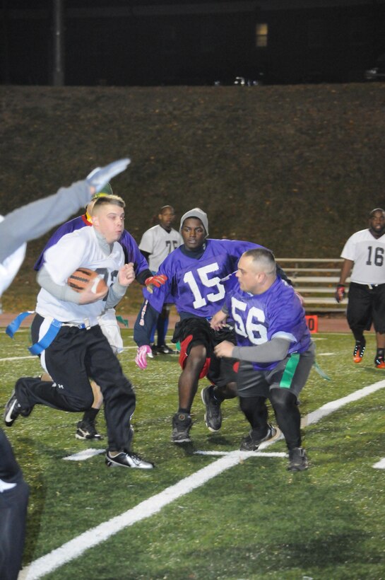 A player for Marine Corps Systems Command’s flag football team jukes to his right to evade three opposing players during an American League game at Butler Stadium on Nov. 19. The teams who compete in the league consist of Marines as well as civilians.