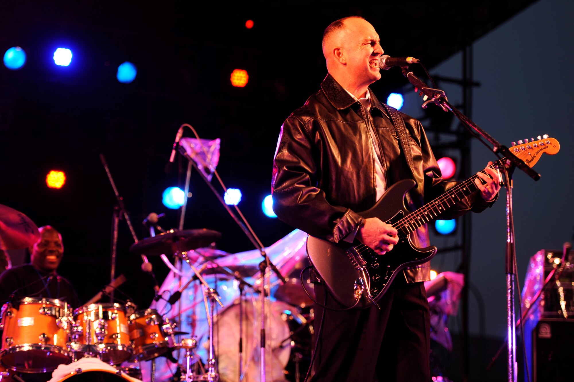 Michael Joiner (right) and Donald Moore, both 9 Long Lives band members, perform "Johnny Be Good" for the crowd during the Tinsel Town holiday festival on Kadena Air Base, Japan, Dec. 1, 2012. Despite dark skies and a constant Okinawan drizzle in the air, the event gave a merry light to the crowd with games, children's rides, concessions, prize giveaways and concerts by several bands including country music star Trace Adkins during his USO tour. (U.S. Air Force photo/Senior Airman Maeson L. Elleman)