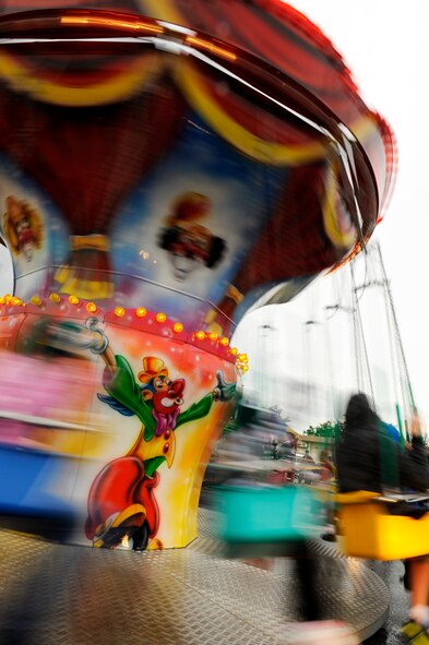 Children ride the swing merry-go-round during the Tinsel Town holiday festival on Kadena Air Base, Japan, Dec. 1, 2012. Despite dark skies and a constant Okinawan drizzle in the air, the event gave a merry light to the crowd with games, children's rides, concessions, prize giveaways and concerts by several bands including country music star Trace Adkins during his USO tour. (U.S. Air Force photo/Senior Airman Maeson L. Elleman)