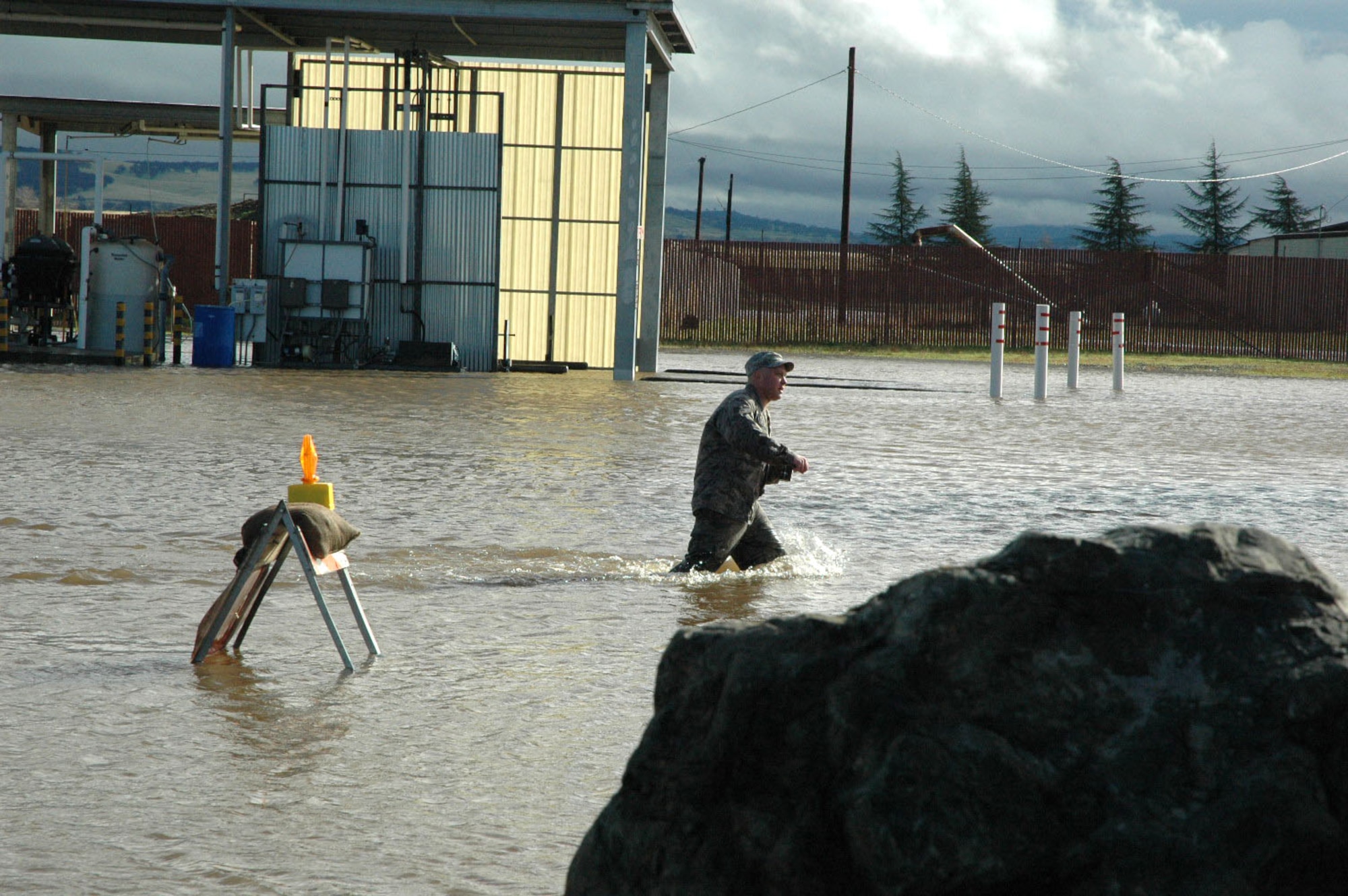 An Airman from the 940th sloshes through more than two feet of water during the December UTA at Beale AFB, Calif. With water rising all over the installation the 940th Civil Engineers and Security Forces Squadrons sprang into action. (U.S. Air Force Photo/Dana Lineback)