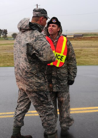 Chief Master Sgt. Robert White, 9th Reconnaissance Wing command chief, thanks an Airman from the 9th Security Forces Squadron for his response during flooding Dec. 2, 2012 at Beale Air Force Base, Calif. Several 9th Security Forces Squadron and 9th Civil Engineer Squadron Airmen where recalled for the emergency.  (U.S. Air Force photo by Senior Airman Shawn Nickel/Released)