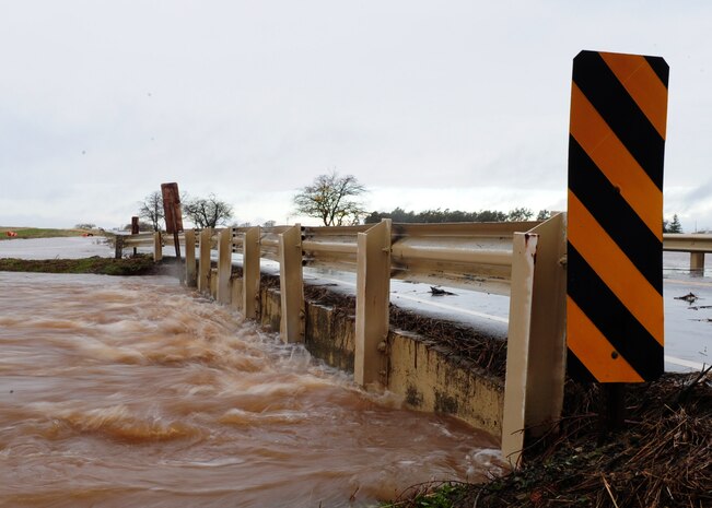 Water bubbles from under a bridge on Gavin Mandery Dr. Dec. 2, 2012, at Beale Air Force Base, Calif. The road, along with several others on base, was closed due to flooding. (U.S. Air Force photo by Senior Airman Shawn Nickel/Released)