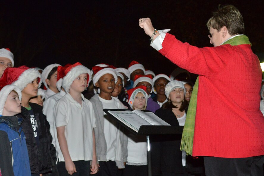 Carolyn Newsome, High Hills Elementary music teacher, directs High Hills and Shaw Heights Elementary students as they sing during the Shaw Christmas tree lighting, at Shaw Air Force Base, S.C. Nov. 29, 2012. The celebration attracted more than 300 participants. (U.S. Air Force photo by Airman 1st Class Ashley L. Gardner/ Released)
