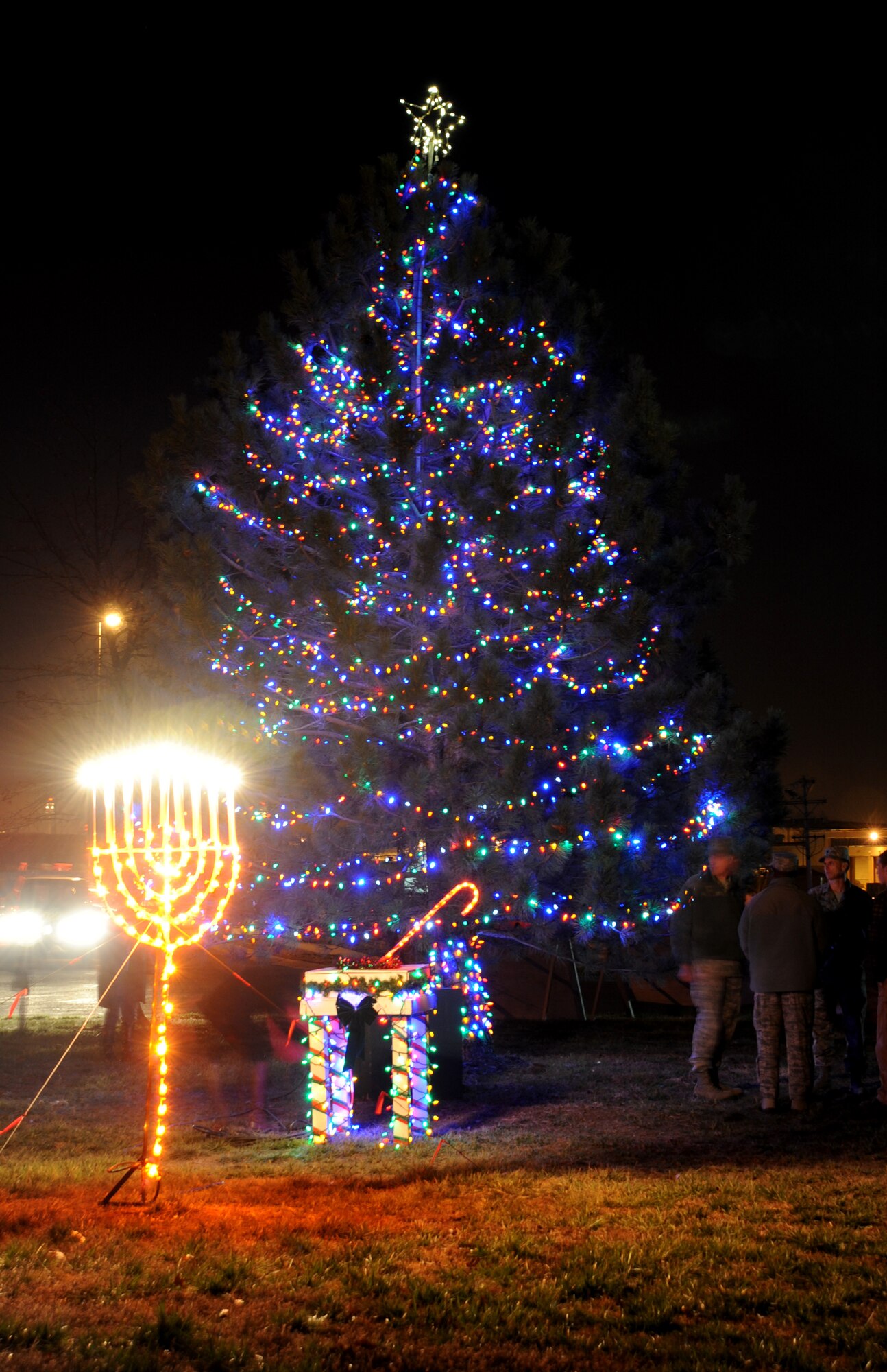 Members of Team Whiteman view the Christmas Tree and Menorah on display during a Christmas Tree/Menorah lighting ceremony Nov. 29 at Whiteman Air Force Base, Mo. The annual lighting ceremonies help  foster morale and esprit de corps among Airmen and families. (U.S. Air Force photo/Senior Airman Nick Wilson) (Released)