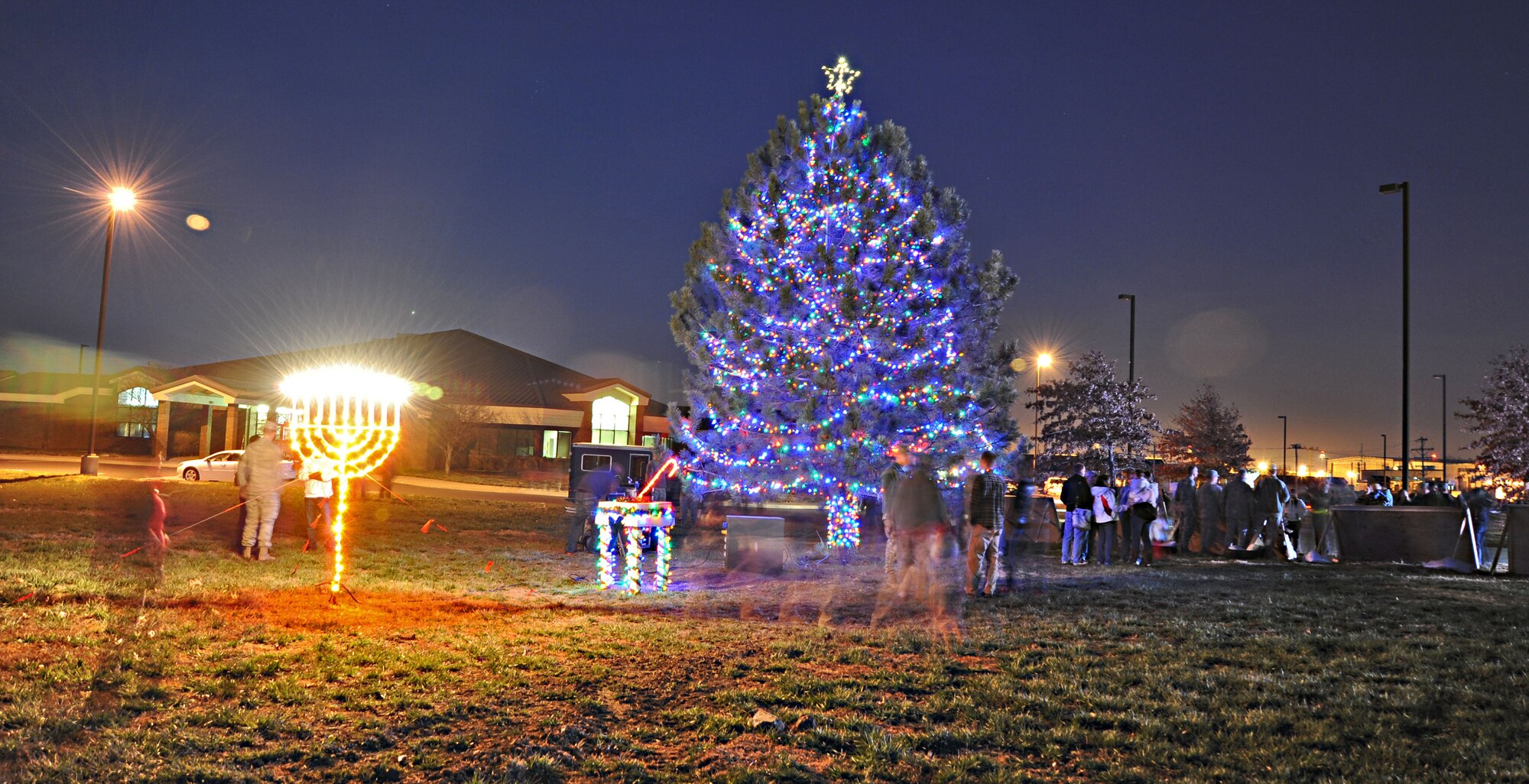 Members of Team Whiteman view the Christmas Tree and Menorah on display during a Christmas Tree/Menorah lighting ceremony Nov. 29 at Whiteman Air Force Base, Mo. The annual lighting ceremonies help  foster morale and esprit de corps among Airmen and families. (U.S. Air Force photo/Senior Airman Nick Wilson) (Released)