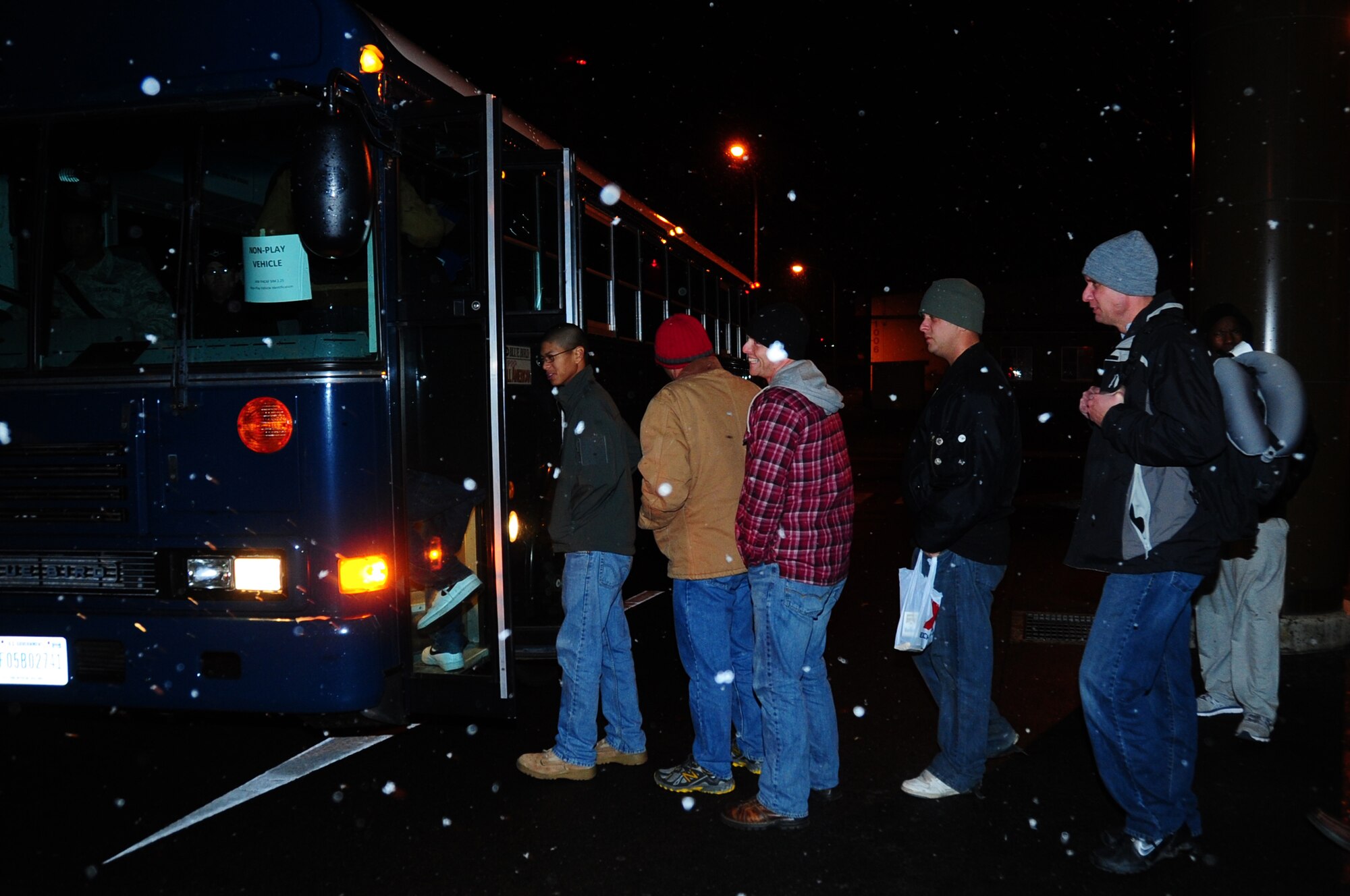 Patriot express passengers board a bus after having a late meal provided by the Misawa Club Complex at Misawa Air Base, Japan, Dec. 4, 2012.  The base provided lodging and meals for more than 240 passengers that unexpectedly returned to the base after their plane experienced mechanical issues.  (U.S. Air Force photo by Staff Sgt. April Quintanilla)