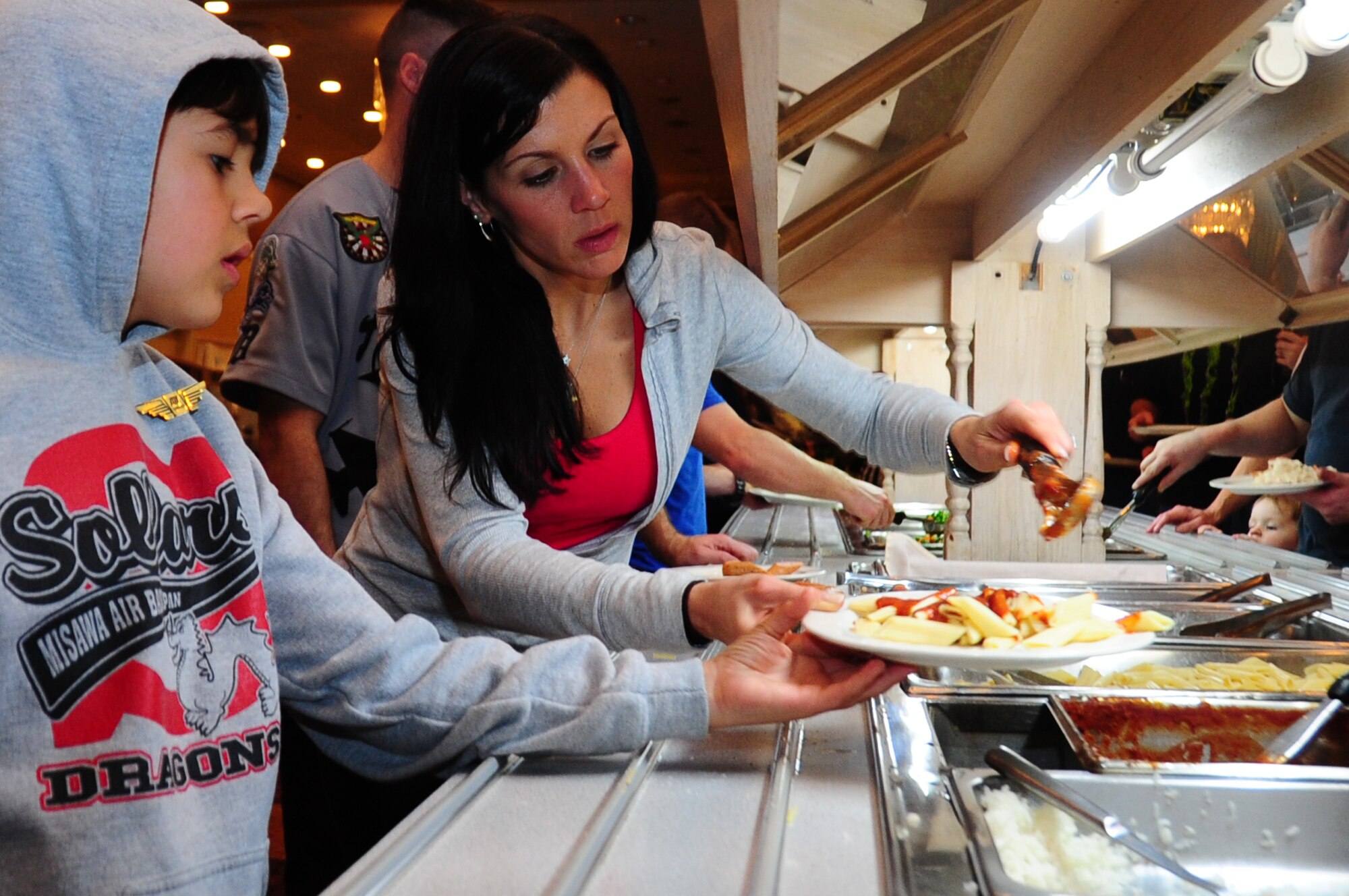 U.S. Air Force Tech. Sgt. Julie Dimmitt, patriot express passenger, makes a plate of food for her son at the Misawa Club Complex after their plane experienced mechanical issue and returned to Misawa Air Base, Japan, Dec. 4, 2012.  Members of the 35th Force Support Squadron arranged lodging and food for more than 240 unexpected passengers.  (U.S. Air Force photo by Staff Sgt. April Quintanilla)