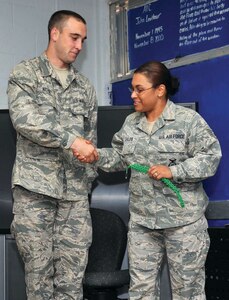 Staff Sgt. Sales removes the Green Rope from Airman Basic Cory Nichols signifies his relinquishing additional duties as he is ready to move on to technical school. (U.S. Air Force Photo/Alan Boedecker)