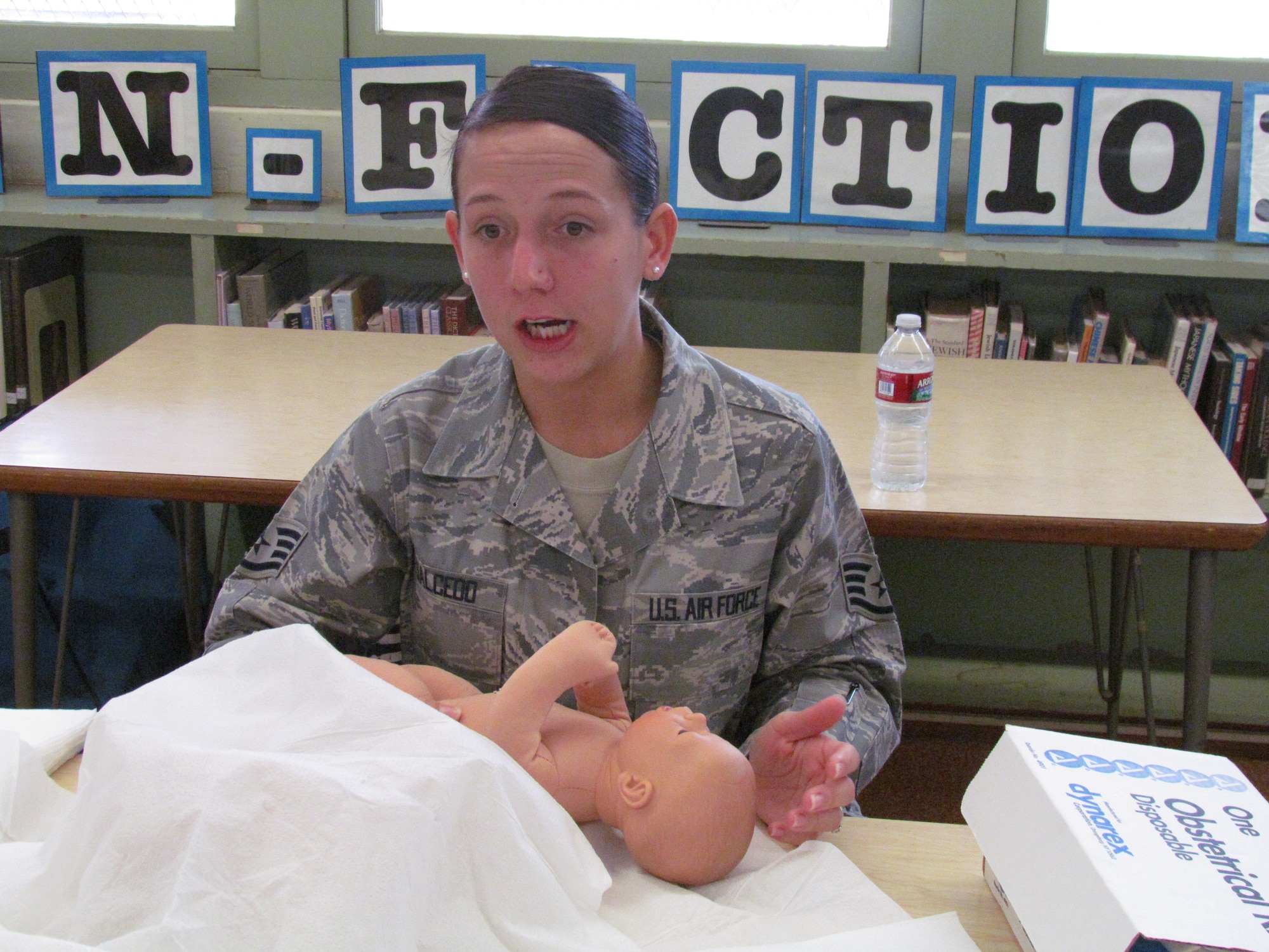 Staff Sgt. Tiffany Salcedo from the 15th Medical Group at Joint Base Pearl Harbor-Hickam, Hawaii, explains obstetrics to students with the use of a lifelike doll during a lesson Nov. 29 at Radford High School. The activity provided students with real-life experience and training in the medical skills needed to effectively care for a patient. (U.S. Navy photo by Don Robbins)


