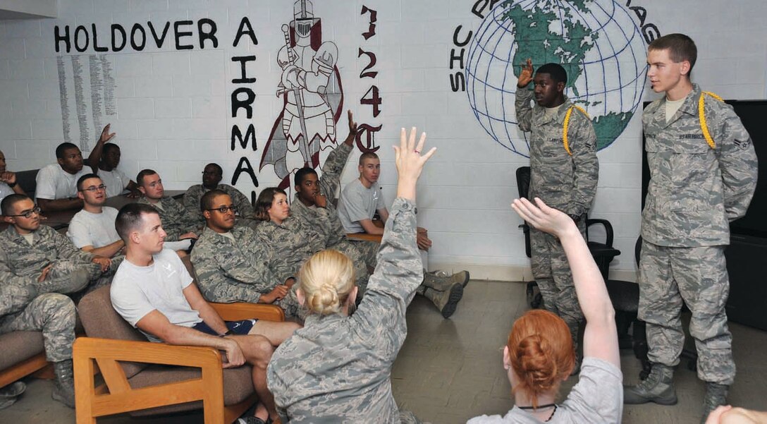 Airman 1st Class Kantrell Gray (left) and Airman 1st Class Connor McCormack deliver the daily briefings and detail assignments for the weekend. (U.S. Air Force Photo/Alan Beodeker) 