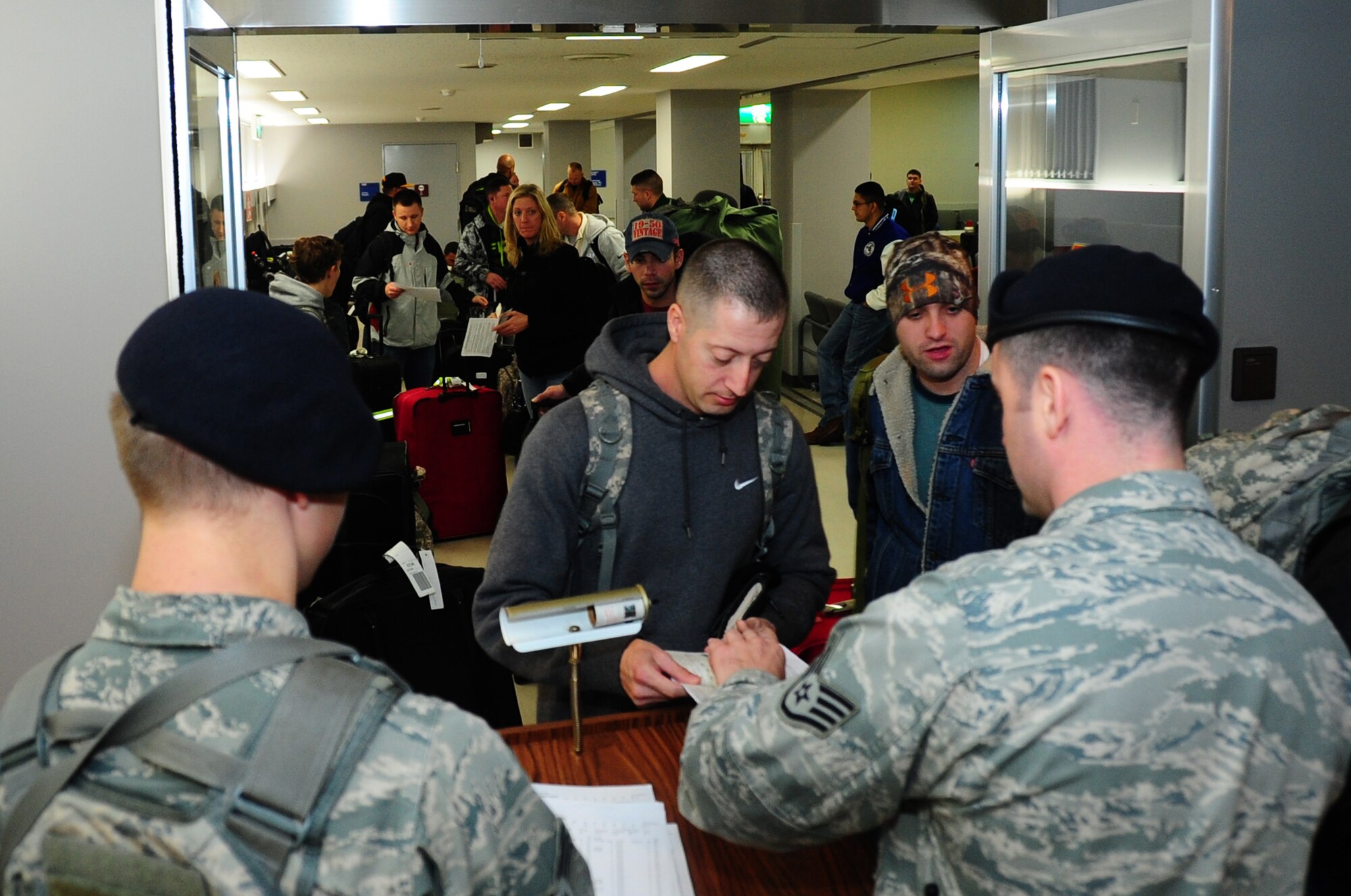 U.S. Air Force Staff Sgt. Richard Phillips III and Senior Airman Samuel Walker, 35th Security Forces Squadron law enforcement desk sergeants, process more than 240 unexpected passengers through customs at Misawa Air Base, Japan, Dec. 4, 2012.  The plane departed the base then experienced a mechanical issue and had to return.  (U.S. Air Force photo by Staff Sgt. April Quintanilla)