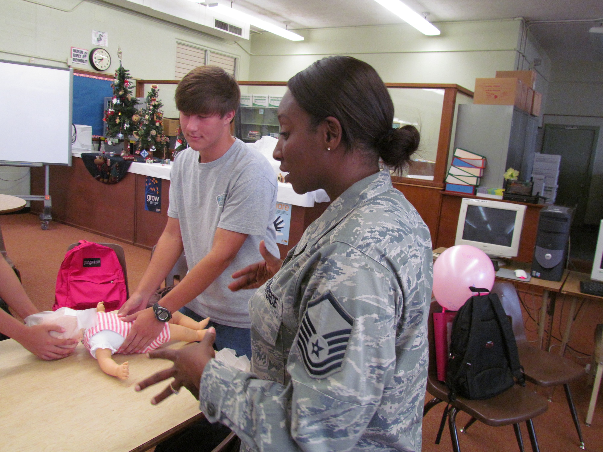 Radford High School 10th grade Matthew Fiala, a 10th-grade student at Radford High School,  learns how to perform infant cardiopulmonary resuscitation Nov. 29 from Master Sgt. Tikama Drummond of the 15th Medical Group at Joint Base Pearl Harbor-Hickam, Hawaii. The activity provided students with real-life experience and training in the medical skills needed to effectively care for a patient. (U.S. Navy photo by Don Robbins)

