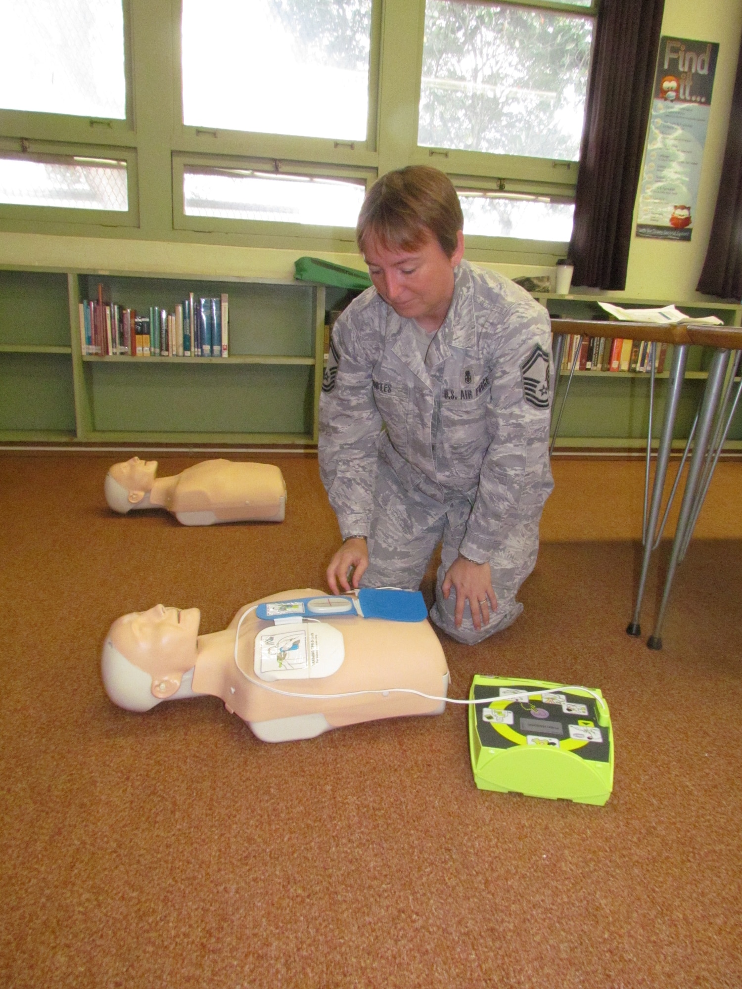 Senior Master Sgt. Michelle Rootes of the 15th Medical Group at Joint Base Pearl Harbor-Hickam, Hawaii, demonstrates how to care for a patient during a lesson Nov. 29 at Radford High School. The activity provided students with real-life experience and training in the medical skills needed to effectively care for a patient. (U.S. Navy photo by Don Robbins)