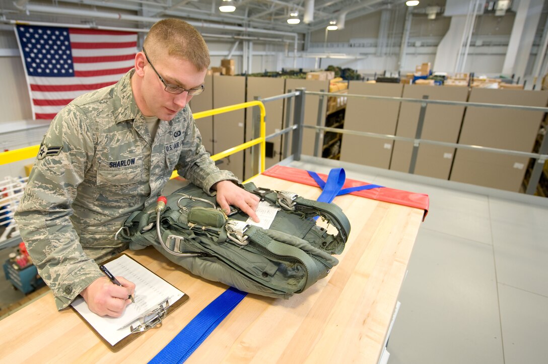 Airman 1st Class Chris Sharlow, 436th Operations Support Squadron Aircrew Flight Equipment journeyman, performs an inspection on a parachute at Dover Air Force Base, Del. on Nov. 30, 2012. He is the creator of a new computer program used to easily track thousands of accountable aircrew equipment items. Sharlow's program is known as the Flight Equipment Automated Records Systems (FEARS) and is being used to ensure tracking and on-time inspections of items critical to safe, efficient mission accomplishment. (U.S. Air Force photo by Greg L. Davis)