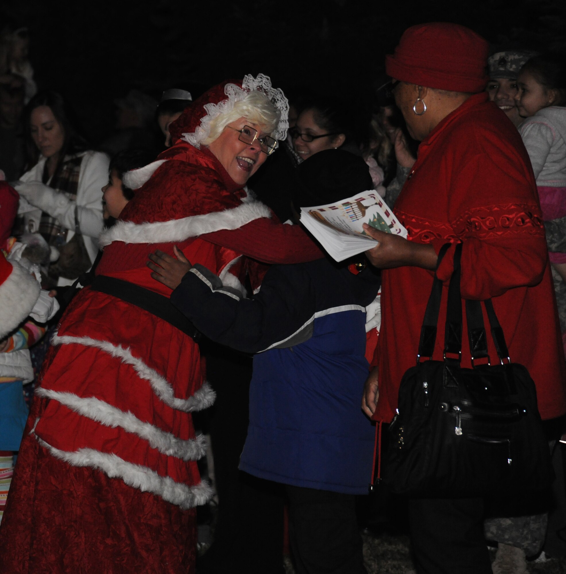 Mrs. Claus greets families upon arrival to the Christmas Tree and Hanukah Menorah Lighting Ceremony at Chapel One, Nov. 29, 2012. The lighting of the tree and menorah is an annual event that consists of singing, menorah and tree lighting, prayer and a visit from Santa and Mrs. Claus. (U.S. Air Force photo/Airman 1st Class Erin O’Shea)  