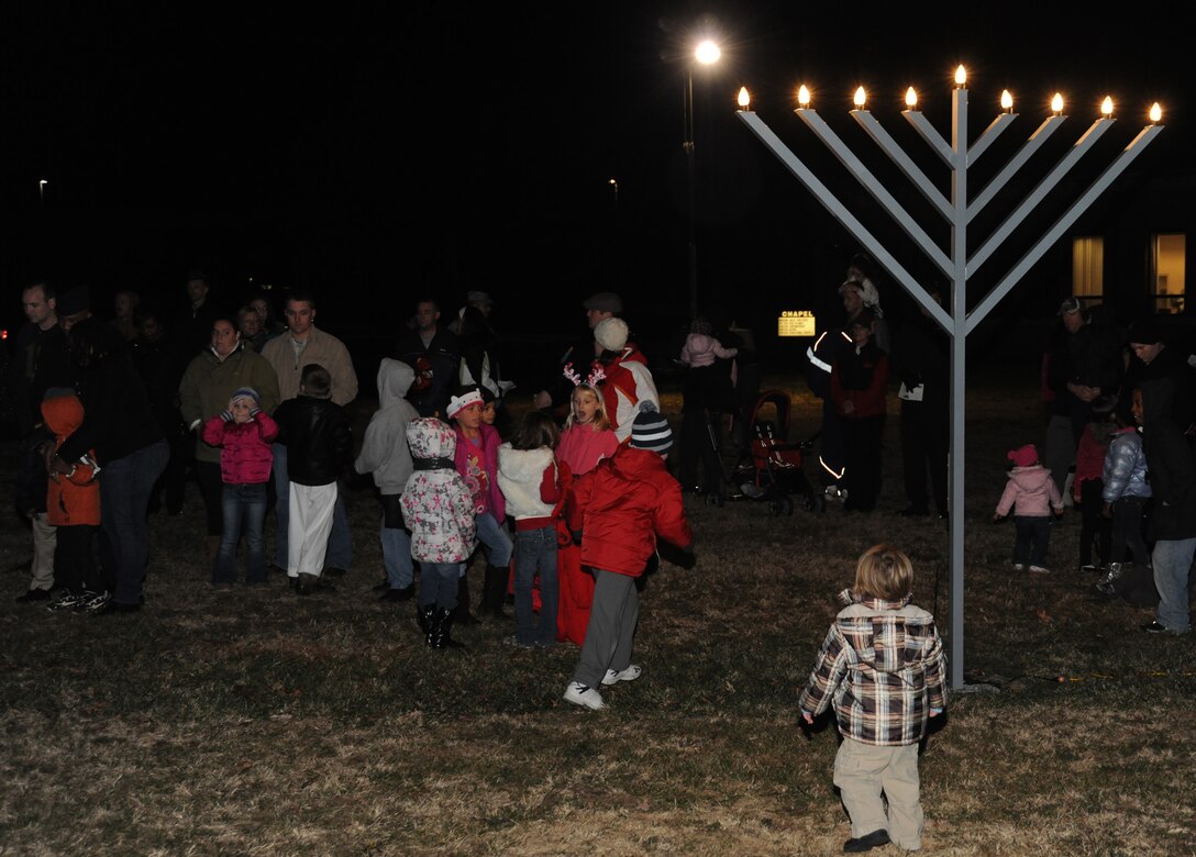 Families gather around the Menorah after it’s lit during the Christmas Tree and Menorah Lighting Ceremony at Chapel One, Nov. 29, 2012. The lighting of the tree and menorah is an annual event that consists of singing, menorah and tree lighting, prayer and a visit from Santa and Mrs. Claus. (U.S. Air Force photo/Airman 1st Class Erin O’Shea)
