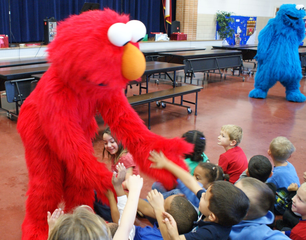 Elmo and Cookie Monster from "Sesame Street Live" dance for students during a visit to the school Dec. 4, 2012.  Both Elmo and the Cookie Monster met the students and participated in story time. (U.S. Air Force photo/Dan Hawkins)