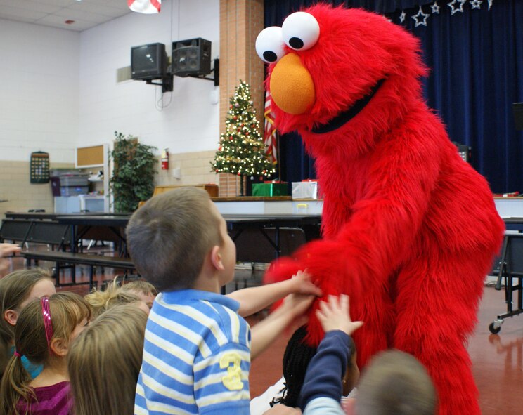 Elmo from "Sesame Street Live" greets students during a visit to the school Dec. 4, 2012.  Both Elmo and the Cookie Monster met the students and participated in story time. (U.S. Air Force photo/Dan Hawkins)
