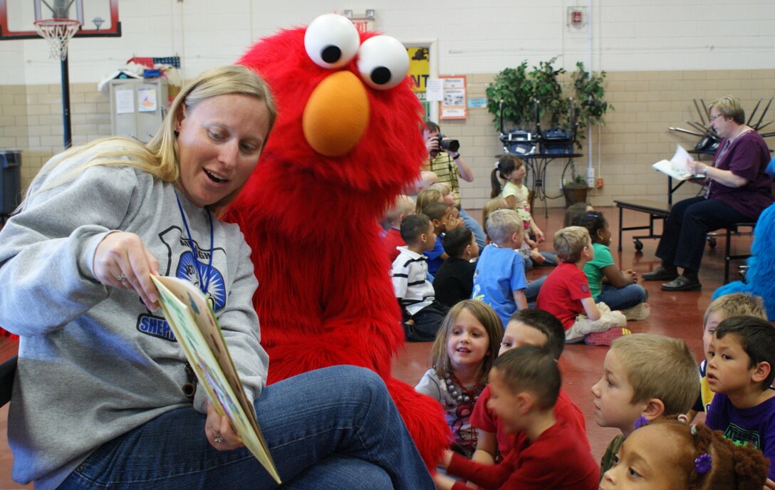 Jennifer Cannaday, Sheppard Elementary School teacher, and Elmo read a book to students during a visit to the school by characters from "Sesame Street Live" Dec. 4, 2012.  Both Elmo and the Cookie Monster met the students and participated in story time. (U.S. Air Force photo/Dan Hawkins)