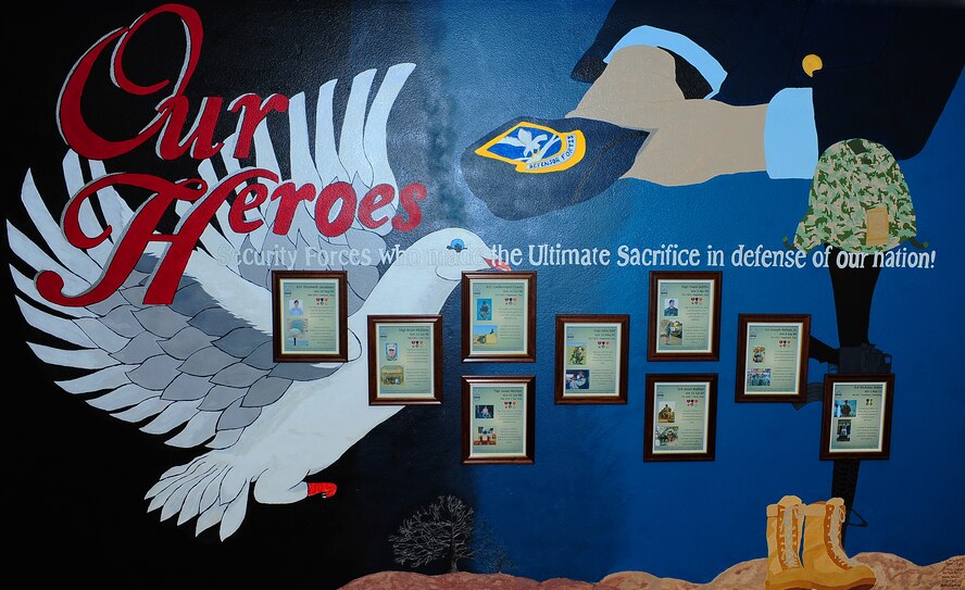 MINOT AIR FORCE BASE, N.D. – Airmen from the 5th Security Forces Squadron paid their respect to their fallen Defender comrades by establishing a Wall of Heroes in their honor. The mural is dedicated to nine Defenders who made the ultimate sacrifice post-9/11. The Wall of Heroes mural can be found in the 5th SFS building, building 547, by the Law Enforcement Desk. (U.S. Air Force Photo/ Kristoffer Kaubisch) 