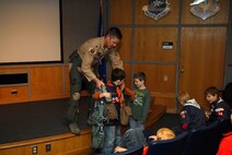 Lt. Col. Matthew McCunn, a pilot with the 115th Fighter Wing, helps a cub scout try on flight gear during a base tour, June 29, 2012 at Truax Field, Madison, Wis. Cub scouts from Pack 76 of Marshal, Wis. were at Truax Field to tour the base and watch some of the fighter wing’s aircraft take off on a night mission. (U.S. Air Force photo by 2nd Lt. Stephen Montgomery)

