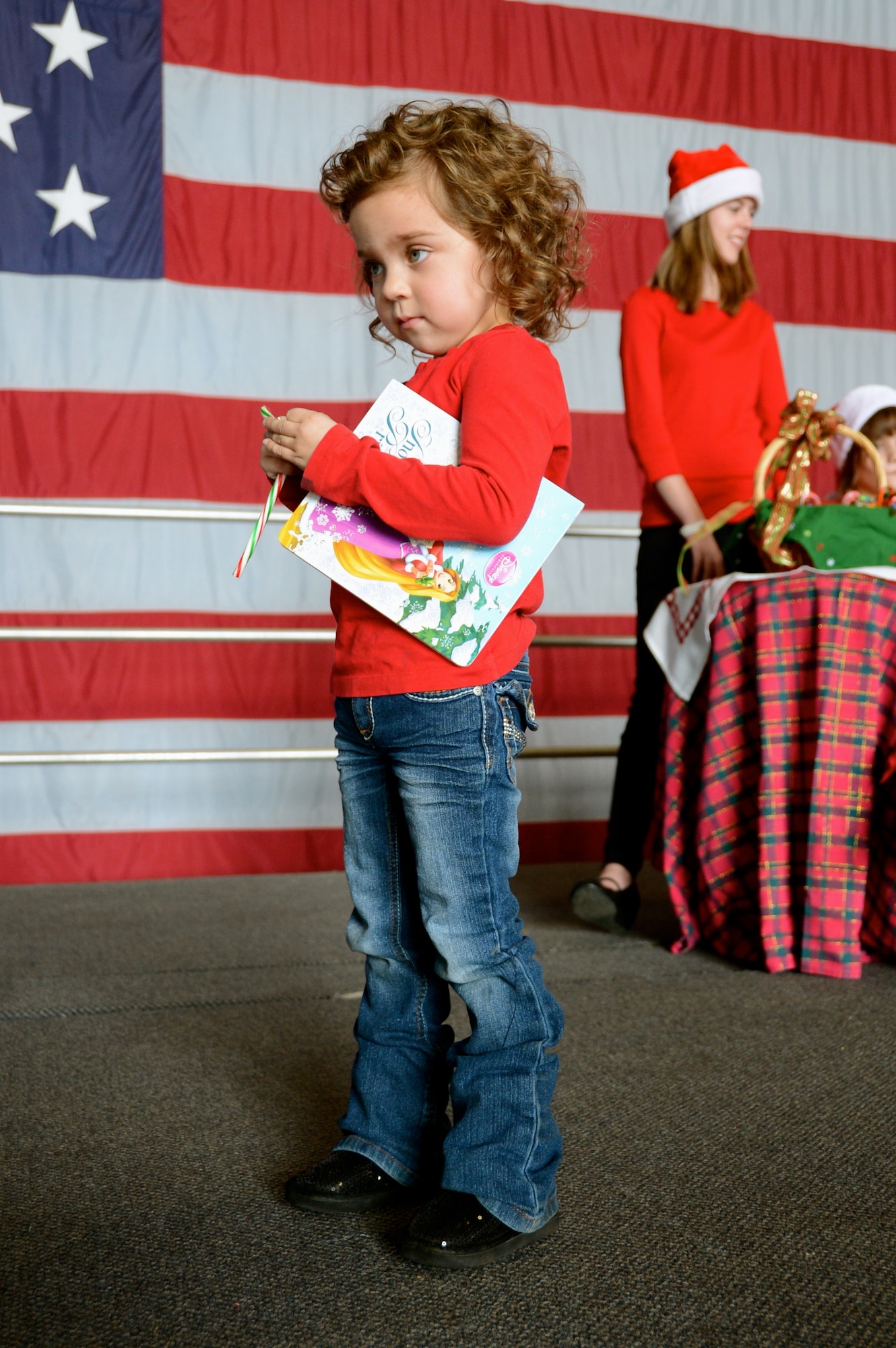 Lexi Hutchinson, daughter of U.S. Air Force Lt. Col. Jared Hutchinson, 55th Fighter Squadron director of operations, looks at her book from Santa at the 20th Operations Group Children's Holiday Party, Shaw Air Force Base, S.C. Dec. 1, 2012. (U.S. Air Force photo by Capt. Ann Blodzinski/Released)
