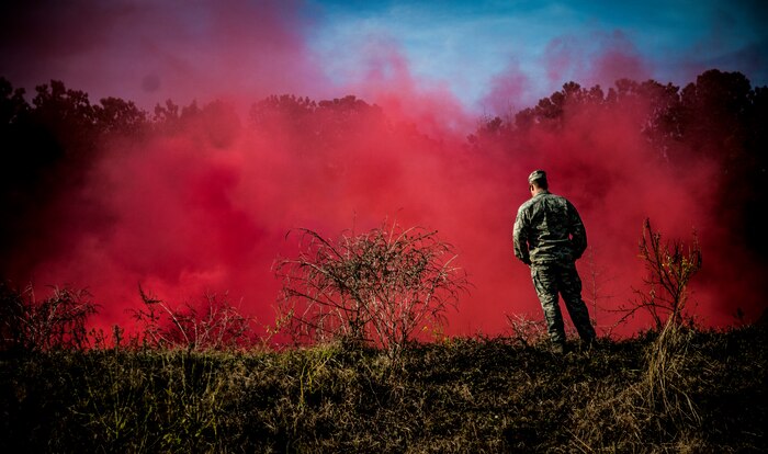 Staff Sgt. Edward Garwick, 628th Explosive Ordnance Squadron craftsman, observes smoke from a smoke grenade during  a Combat Readiness Training session Nov. 30, 2012, at Joint Base Charleston – Air Base, S.C. Garwick instructed Airmen on proper grenade handling and throwing procedures.(U.S. Air Force photo/ Senior Airman Dennis Sloan)
