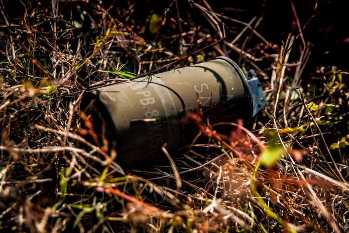 A smoke grenade lies in the grass after being thrown into a ditch during a Combat Readiness Training session with the 628th Explosive Ordnance Squadron Nov. 30, 2012, at Joint Base Charleston, S.C. Airmen attended an hour-long class to review safety procedures when handling grenades.  (U.S. Air Force photo/ Senior Airman Dennis Sloan)