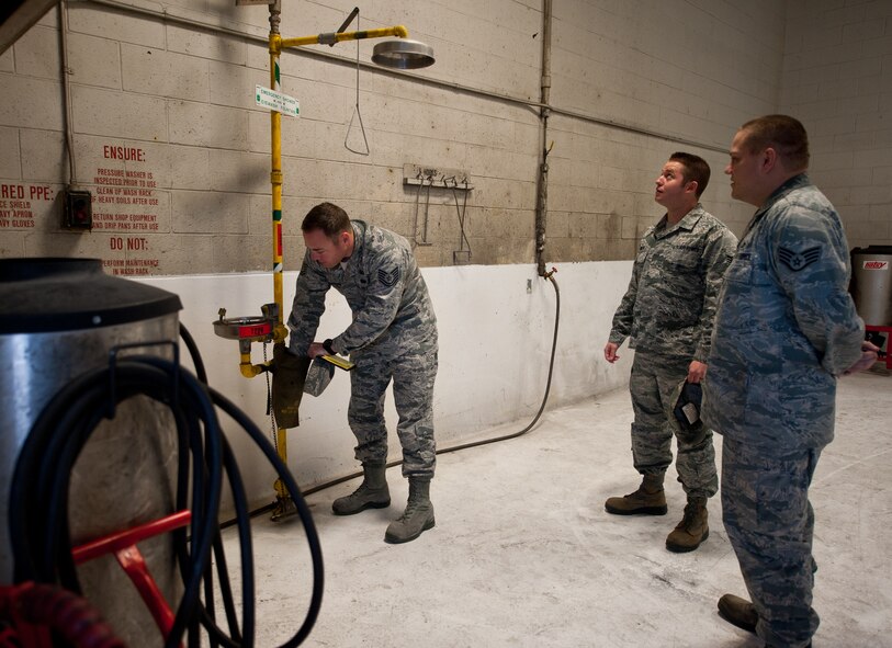 Tech. Sgt. Shane Christian and Staff Sgt. Joel Nobles, 28th Bomb Wing Staff ground safety technicians, inspect the emergency eye wash and shower station with Staff Sgt. Benjamin Wood, 28th Maintenance Squadron aerospace ground equipment technician, at the 28th MXS AGE shop on Ellsworth Air Force Base, S.D., Nov. 29, 2012. Each section is responsible to inspect these stations every month to ensure equipment is working properly in case of an emergency. (U.S. Air Force photo by Airman 1st Class Alystria Maurer/Released)
