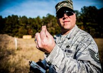 Tech. Sgt. Frederick Sheppard, 1st Combat Camera Squadron noncommissioned officer in charge of supply, pulls the pin on a Ground Burst Simulator during Combat Readiness Training with the 628th Explosive Ordnance Squadron Nov. 30, 2012, at Joint Base Charleston – Air Base, S.C. Once the pin is pulled from a GBS, a rip cord prevents the grenade from exploding. (U.S. Air Force photo/ Senior Airman Dennis Sloan)