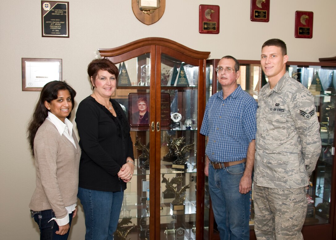 (Left to right) Vashti Hawkins, Renee Gifford, Chris Lamiroult and Senior Airman Andrew Hoffman, all part of the 82nd Contracting Squadron, stand next to a photo of the late Tandy Weaver, former business operations director for the 82nd CONS Nov. 30, 2012, after the 82nd CONS received the AETC Small Business Achievement Award. The award recognizes units who meet all of their small business goals for the fiscal year. (U.S. Air Force photo/Danny Webb) 