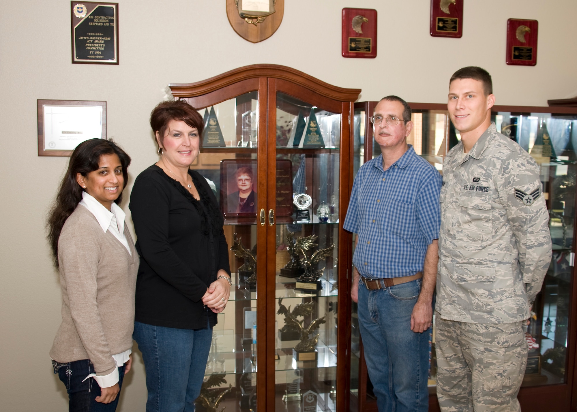 (Left to right) Vashti Hawkins, Renee Gifford, Chris Lamiroult and Senior Airman Andrew Hoffman, all part of the 82nd Contracting Squadron, stand next to a photo of the late Tandy Weaver, former business operations director for the 82nd CONS Nov. 30, 2012, after the 82nd CONS received the AETC Small Business Achievement Award. The award recognizes units who meet all of their small business goals for the fiscal year. (U.S. Air Force photo/Danny Webb) 