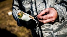 Tech. Sgt. Frederick Sheppard, 1st Combat Camera Squadron noncommissioned officer in charge of supply, pulls the rip cord from a Ground Burst Simulator grenade moments before throwing the grenade into a ditch during Combat Readiness Training with the 628th Explosive Ordnance Squadron Nov. 30, 2012, at Joint Base Charleston – Air Base, S.C. Airmen throw both a GBS grenade and a smoke grenade for training purposes. (U.S. Air Force photo/ Senior Airman Dennis Sloan)