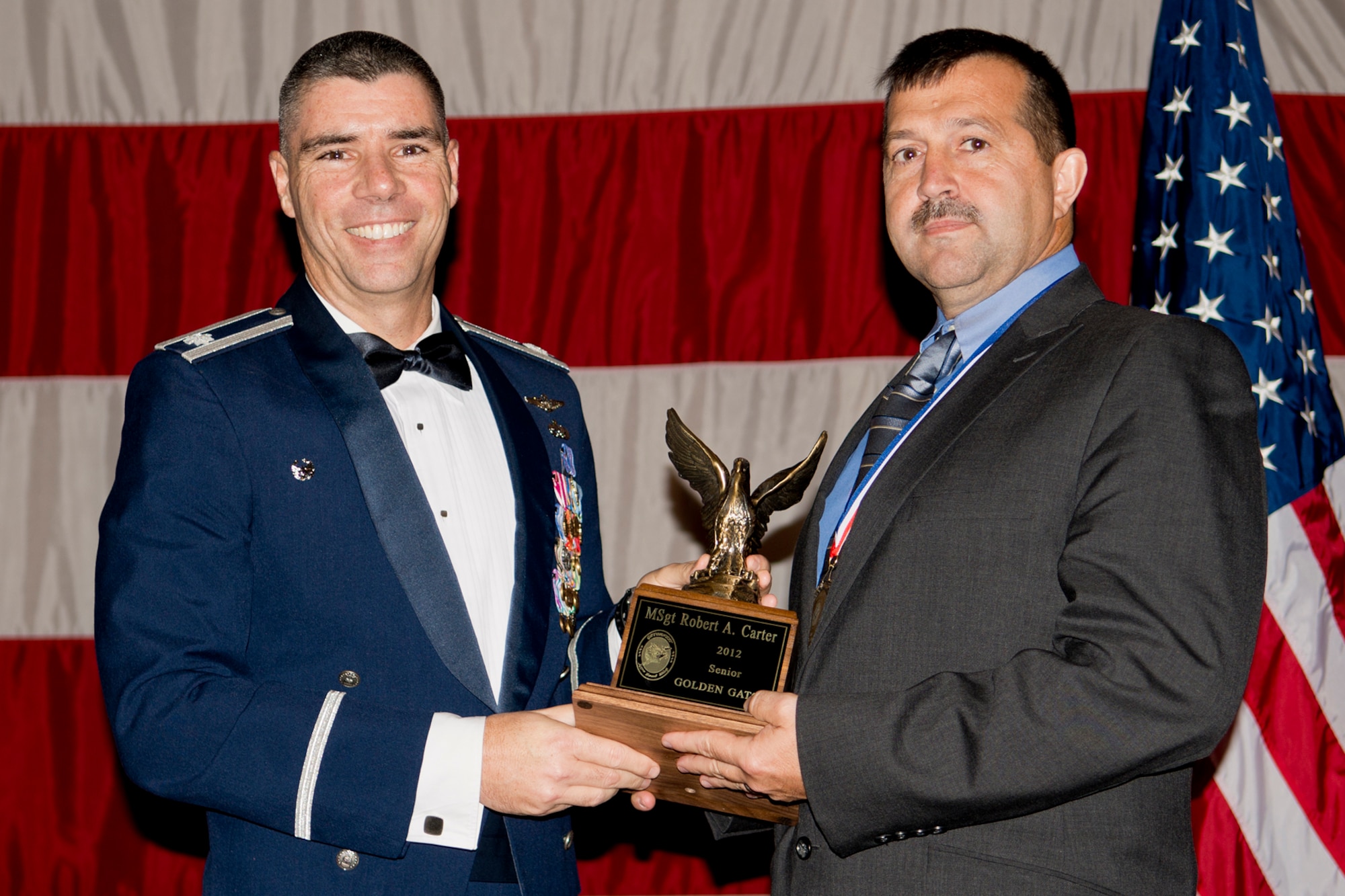 U.S. Air Force Lt. Col. Kenneth Rose, 307th Maintenance Group commander, presents the Senior Golden Gator Award to Master Sgt. Robert Carter, 307th Aircraft Maintenance Squadron, Dec. 1, 2012, Barksdale Air Force Base, La. This award is given to the senior noncommissioned officer who made the greatest contribution with their career field to the 307th Bomb Wing maintenance community. (U.S. Air Force photo by Master Sgt. Greg Steele/Released)