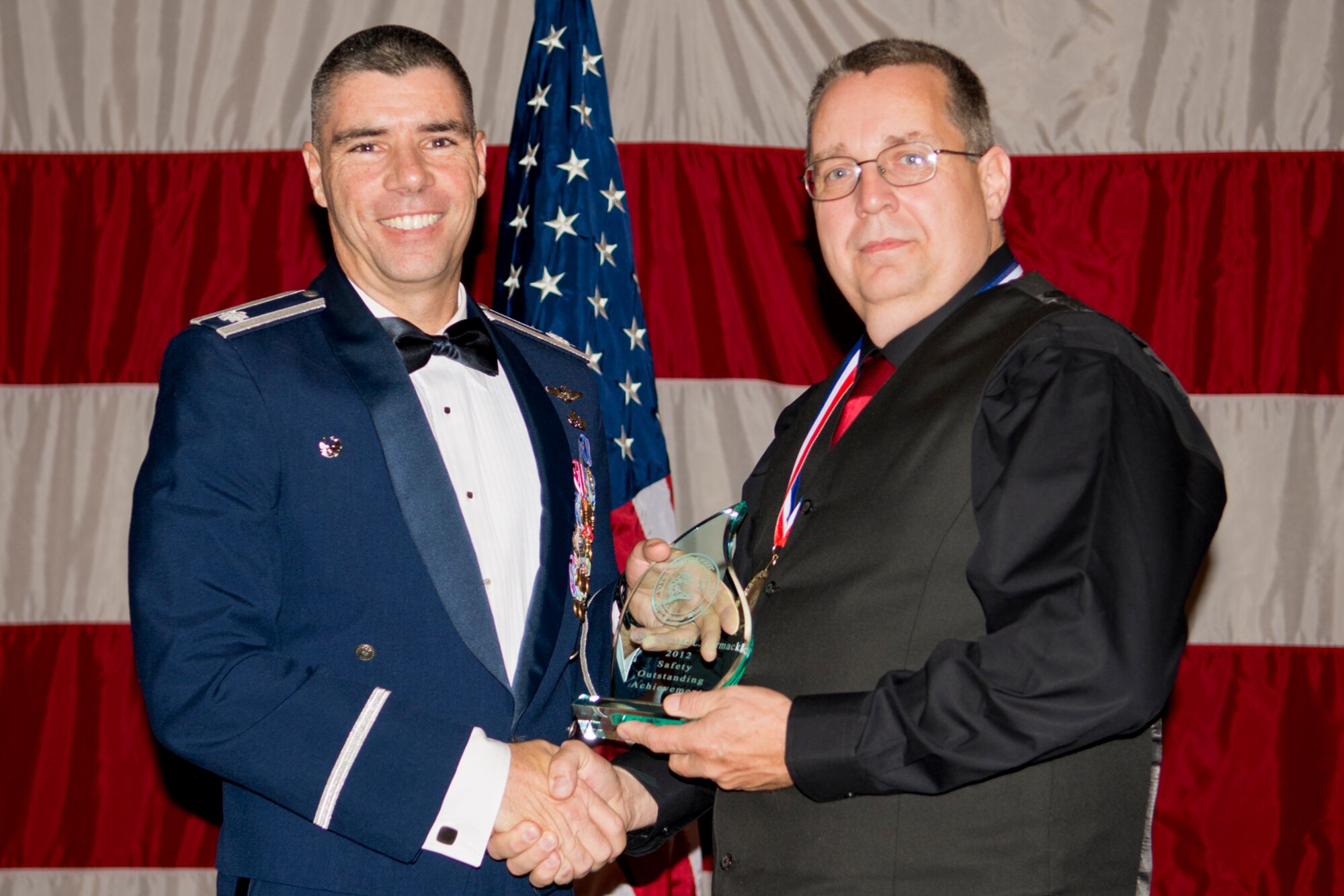 U.S. Air Force Lt. Col. Kenneth Rose, 307th Maintenance Group commander, presents the Gatorfest Safety Award to Clarence Carmack, 307th Aircraft Maintenance Squadron, Dec. 1, 2012, Barksdale Air Force Base, La. The award is given to an individual or individuals whose performance within the past year has contributed greatly to the overall safety of the maintenance community. (U.S. Air Force photo by Master Sgt. Greg Steele/Released)