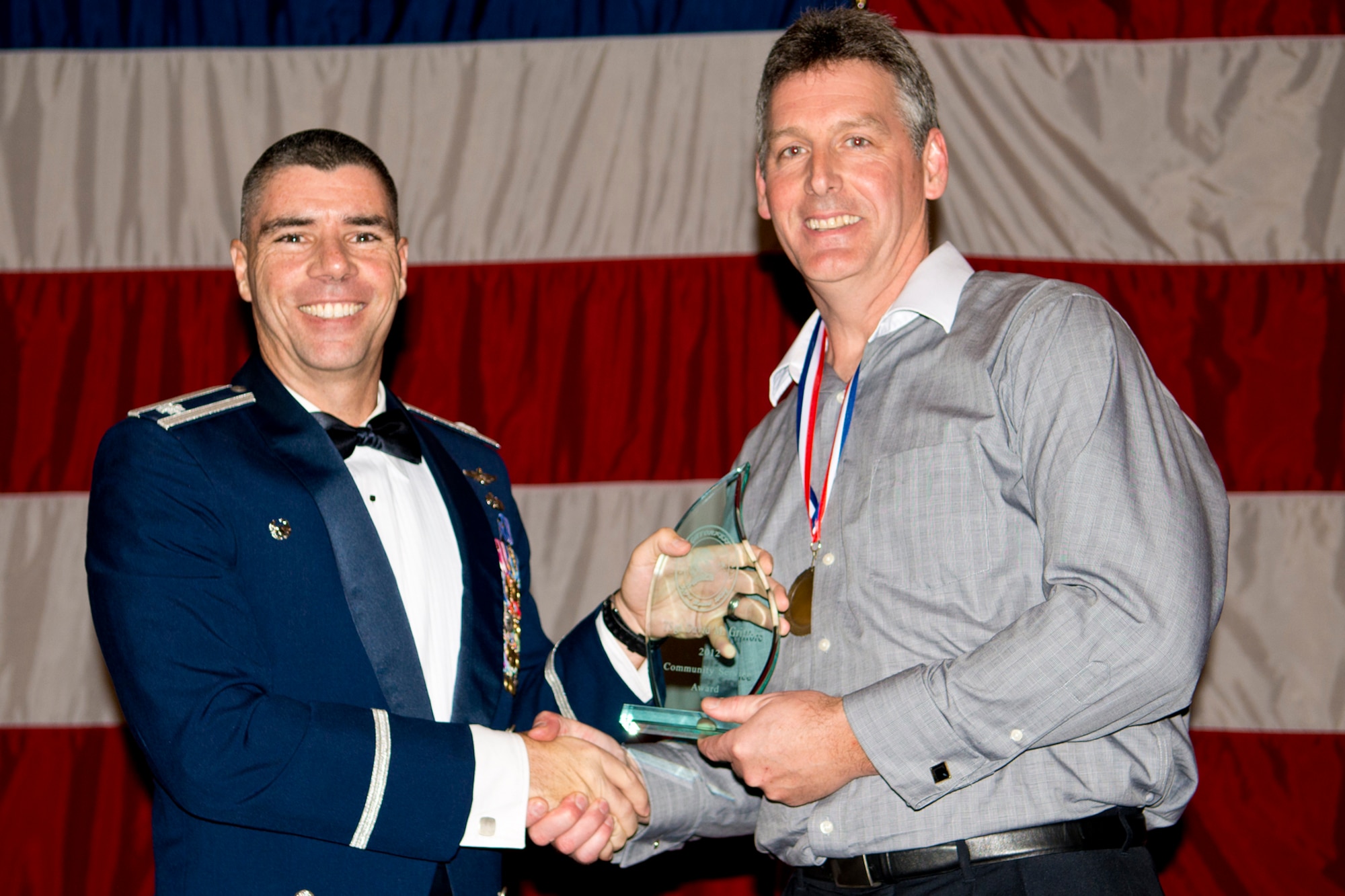 U.S. Air Force Lt. Col. Kenneth Rose, 307th Maintenance Group commander, presents the Community Service Award to David Griffore during Gatorfest, Dec. 1, 2012, Barksdale Air Force Base, La. The purpose of Gatorfest is to enhance morale and esprit de corps, as well as recognize outstanding Airmen assigned to the 307th Bomb Wing. (U.S. Air Force photo by Master Sgt. Greg Steele/Released)