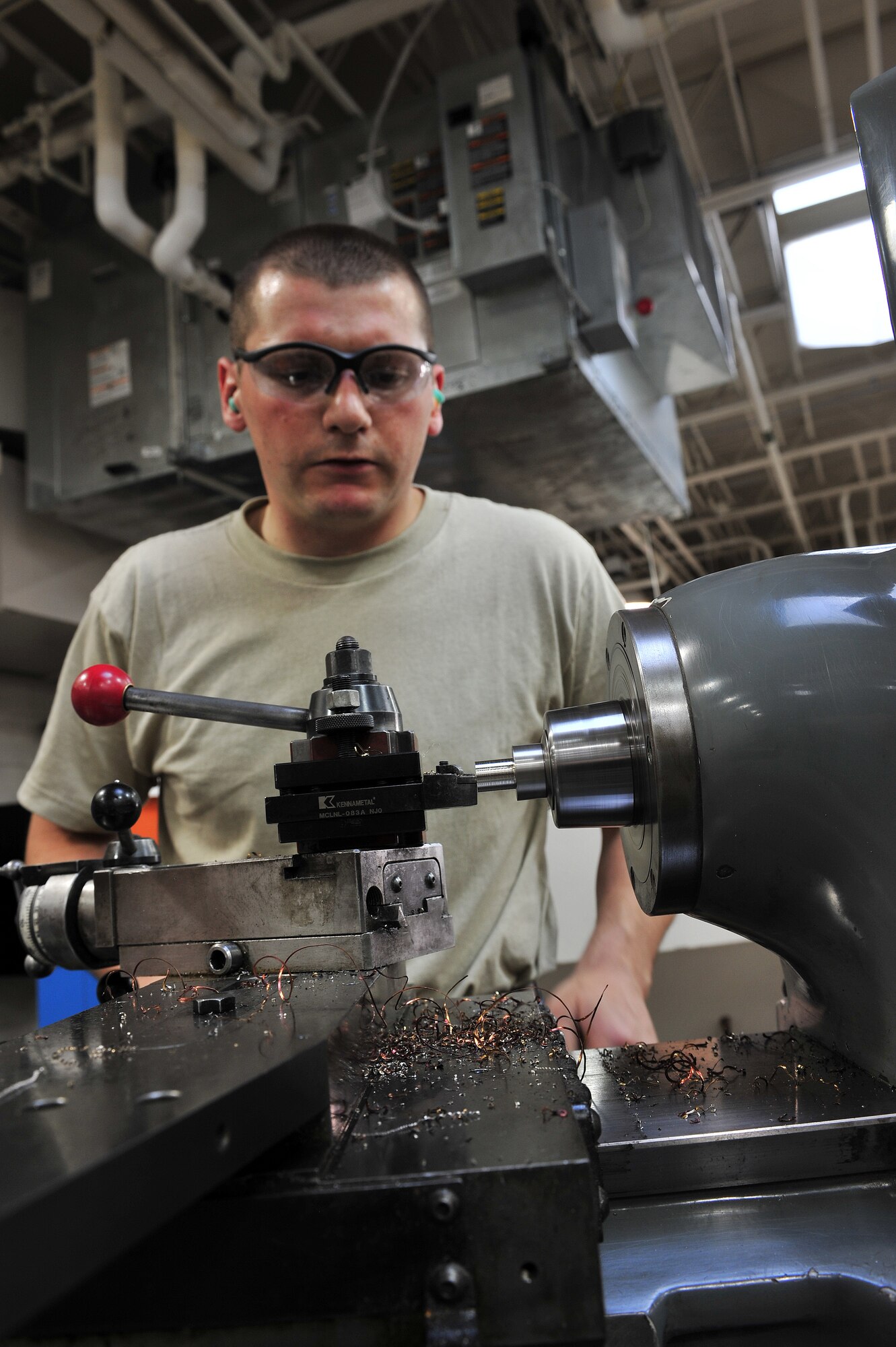 U.S. Air Force Airman 1st Class Donovan Timek, 355th Equipment Maintenance Squadron aircraft metals technology journeyman, turns a piece of stainless steel on a lathe on Davis-Monthan Air Force Base, Ariz., Nov 27, 2012. The Lathe can accurately get you within a thousandth of an inch of your final measurement; this is good for making a bushing. (U.S. Air Force Photo by Airman 1st Class Josh Slavin/Released)
