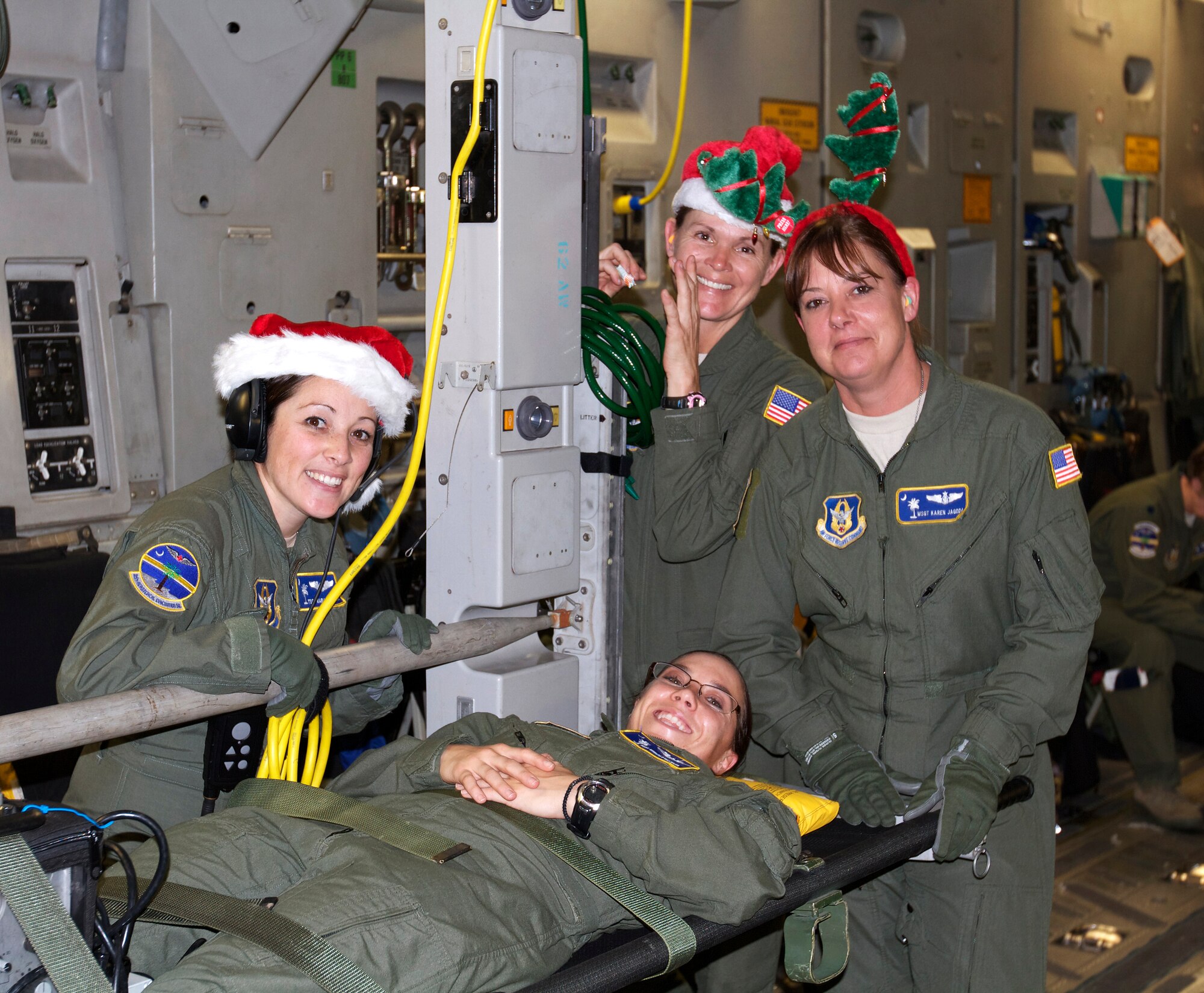 'It's beginning to look a lot like Christmas!' The 315th Aeromedical Evacuation Squadron's (from left) Tech Sgt. Maria Wesloh, Staff Sgt. Brigid Dye,  Master Sgt. Karen Jagoda and Tech Sgt. Kimberly Beaudoin on the litter, show a little holiday spirit during a recent 315th Airlift Wing Mission. (U.S. Air Force Photo / Senior Master Sgt. Dean Carter)
