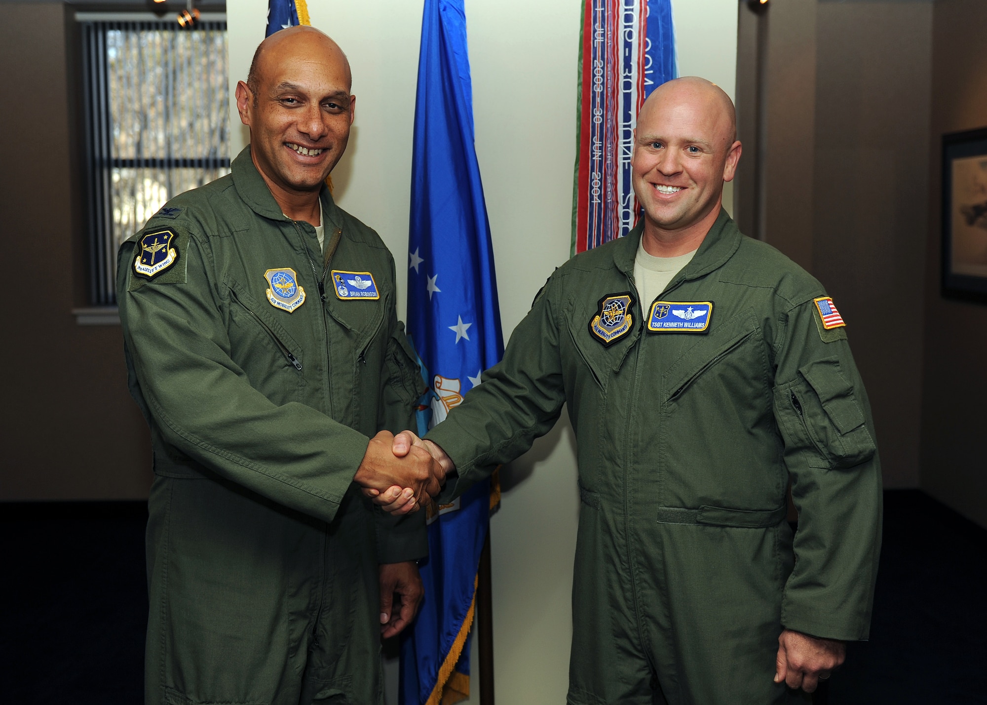 Tech Sgt. Kenneth Williams, a 19th Operations Group evaluator flight engineer, receives a coin from Col. Brian Robinson, 19th Airlift Wing commander, Nov. 16, 2012 at Little Rock Air Force Base, Ark. Williams was selected as the Combat Airlifter of the Week for contributions to his unit and his Airmen. (U.S. Air Force photo by Staff Sgt. Jessica Condit)