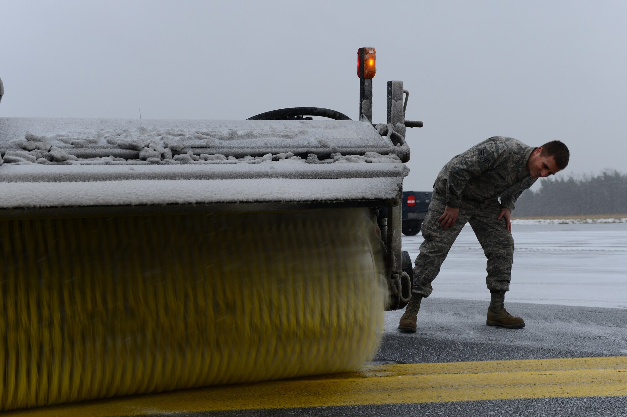 SPANGDAHLEM AIR BASE, Germany – U.S. Air Force Senior Airman Joshua Lemanski, 52nd Civil Engineer Squadron pavement maintenance and heavy equipment operator from Pittsburgh, checks the broom height on a snow broom vehicle Dec. 3, 2012. Lemanski checks the height of the broom to prevent damage to itself and the road surface. (U.S. Air Force photo by Airman 1st Class Dillon Davis/Released)