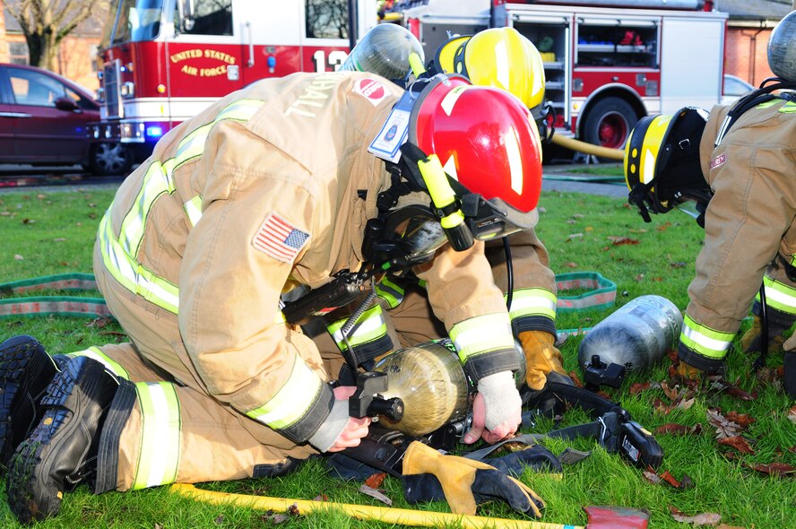 Firefighters replace their oxygen bottles after responding to a smoke-filled building Dec. 3, 2012, during an operational readiness exercise at RAF Mildenhall, England. The ORE, which runs to Dec. 7, is one of many in preparation for a combined unit inspection in 2013. (U.S. Air Force photo by Karen Abeyasekere/Released)
