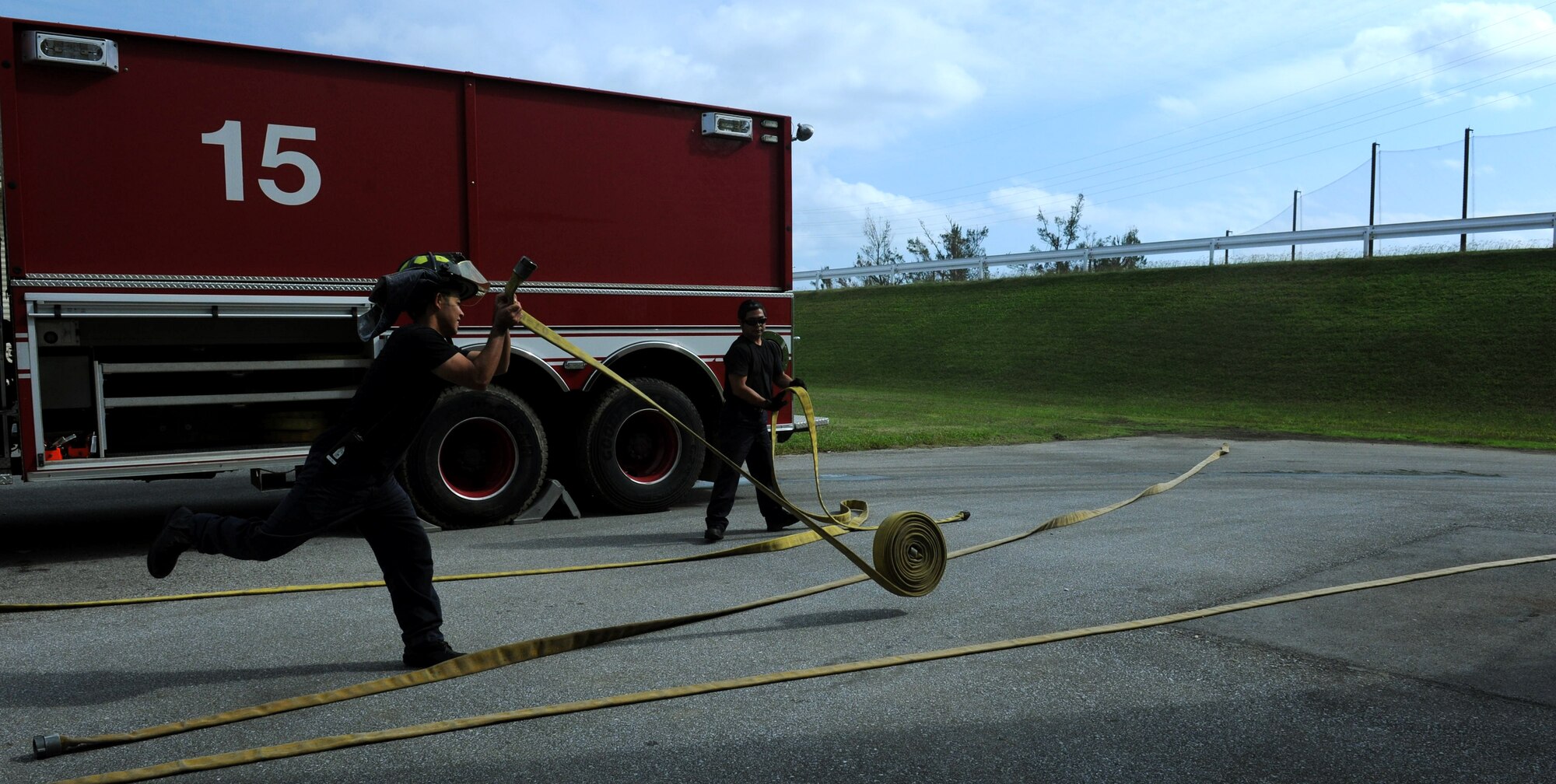 Firefighters roll out four water hoses to prepare for a structural burning training exercise on Kadena Air Base, Japan, Nov. 29, 2012. Kadena firefighters participated in a simulated building search, rescuing casualties and putting out a fire on the second floor of the building. They also had to combat a simulated kitchen fire in the building. (U.S. Air Force photo/Airman 1st Class Hailey R. Davis)