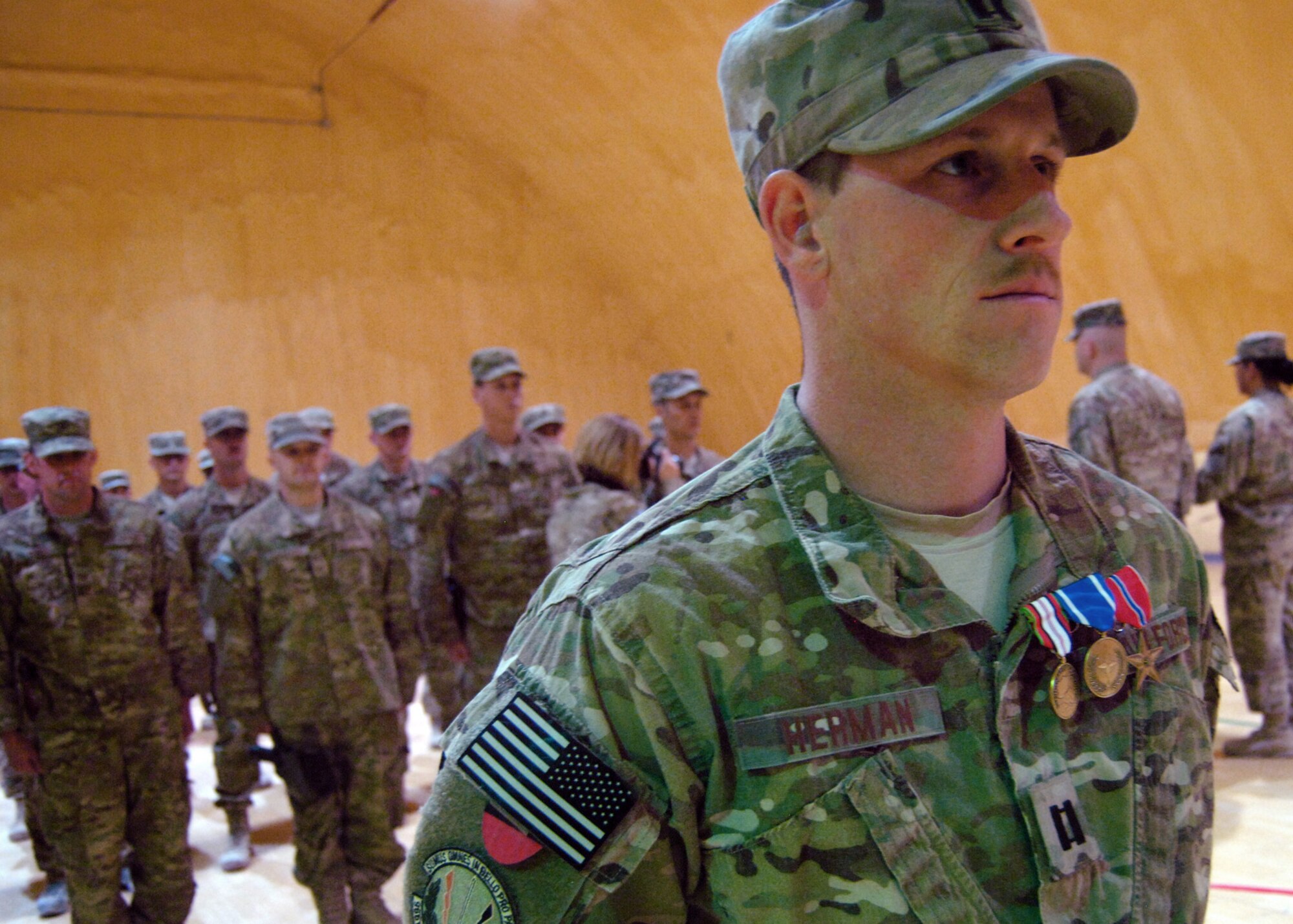 Capt. Jonathan Herman, deployed from the 96th Civil Engineer Squadron, Eglin Air Force Base, Fla., stands at parade rest after being awarded the Afghanistan Campaign Medal, NATO Medal and the Bronze Star Medal. Herman’s explosive ordnance disposal Airmen cleared 98 IEDs, destroyed more than 29,000 pounds of explosives, provided post-blast analysis 16 times, and cleared more than two kilometers of roadway so U.S. and Coalition Forces could patrol outside the wire during their six-month deployment to Kandahar Airfield. (U.S. Air Force photo/Master Sgt. Russell Martin)