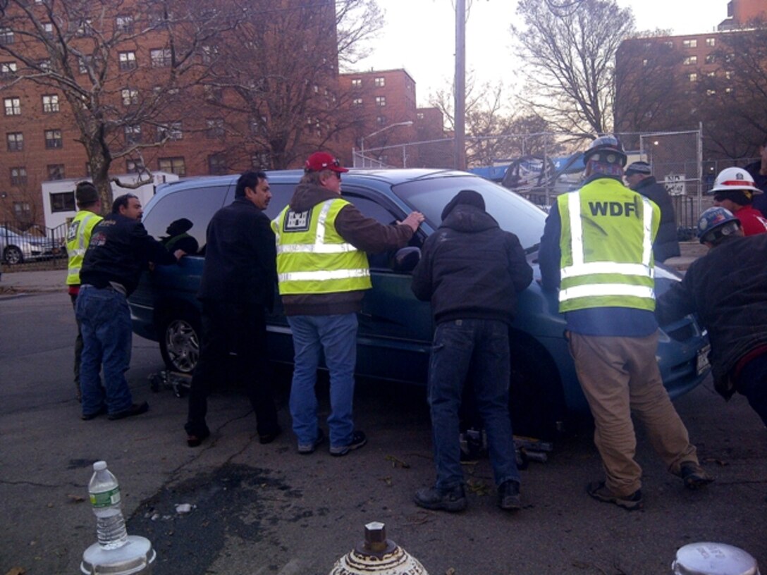 U.S. Army Corps of Engineers personnel, members of the New York City Police Department and the New York City Housing Authority team up to move a car so that a power generator can be placed at a nearby apartment building. The USACE Power Planning and Response Team was deployed to New York City in support of the power mission assigned to USACE by FEMA after Superstorm Sandy caused widespread power outages in October.