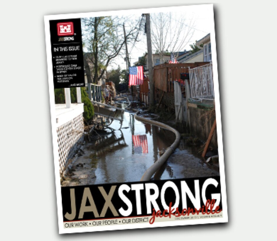 On the Cover - JaxStrong Dec 2012 - An American flag is reflected in a sand- and debris-filled alley in Breezy Point, N.Y., Nov. 9, where service members operating under the U.S. Army Corps of Engineers through a FEMA mission assignment cleared debris, conducted assessments, and pumped water from critical facilities and public housing areas in devastated beachfront communities. The joint task force used more than 70 pumps in 15 public housing complexes and one waste water treatment plant. In Breezy Point, Queens, they pumped an average of 750,000 to 1 million gallons of water per day.