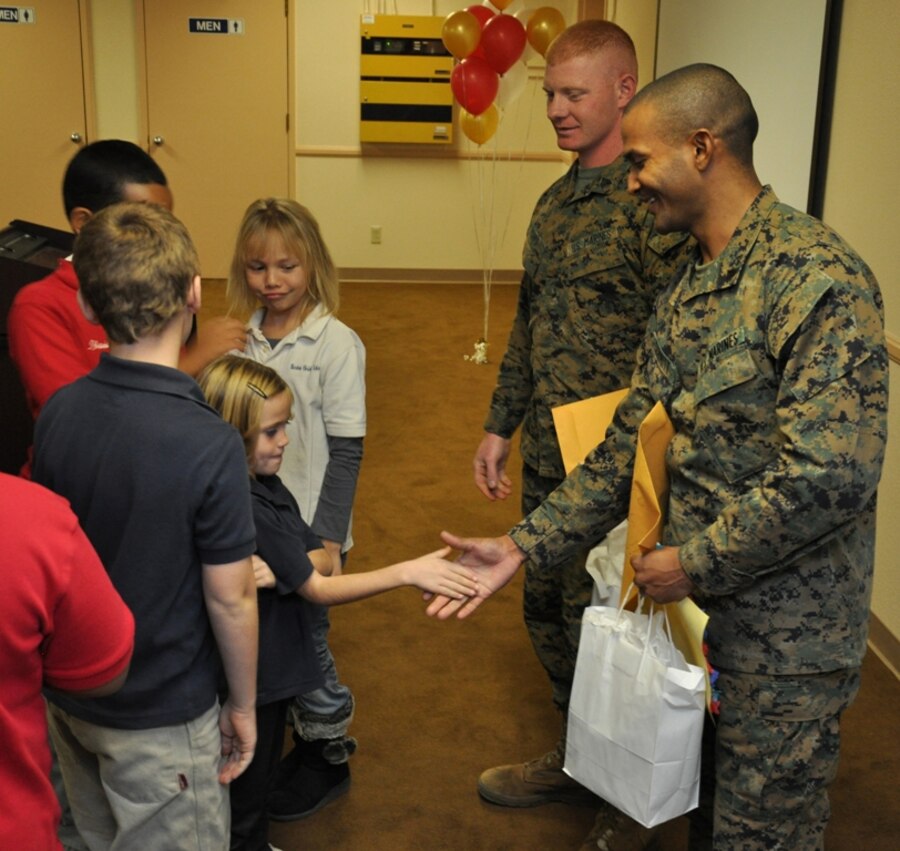 Students of the Barstow Christian School shake hands with Sgt. Jacey Marks and Cpl. Christopher Schmitt, Marines stationed aboard Marine Corps Logistics Base Barstow during the Welcome Home Heroes event held Nov. 27 aboard the base. During the event, guests welcomed back the two Marines from their deployments.