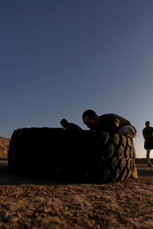 Staff Sgt. Jaime Butler, administration chief, 3rd Battalion, 9th Marine Regiment, Regimental Combat Team 7, begins to flip a tire during a physical fitness session, Nov. 25, 2012. Butler, from Warren, Mich., used the workout as an opportunity to meet different Marines with the battalion.