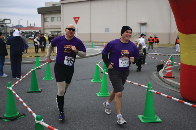 Luke Peet and James Ward, both  Heat the Streets duathletes, run across the finish line in front of the IronWorks Gym here, Dec. 2, 2012. Ninety Japanese and 32 station personnel participated in this year's duathlon.